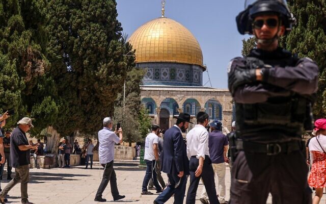 A member of the Israeli security forces stands guard as a group of Jews enters the Temple Mount in Jerusalem, during the annual Tisha B'Av fast day, on July 18, 2021. (Ahmad Gharabli/AFP)