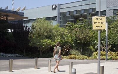 In this file photo taken on August 28, 2016, a woman walks outside the building housing the Israeli NSO group, in Herzliya. (Jack Guez/AFP)