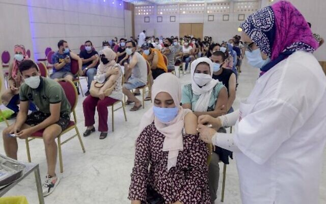 In this file photo taken on July 20, 2021, a Tunisian woman receives a dose of the Chinese Sinopharm vaccine at the Palais des Congres in the capital Tunis.(Fethi Belaid/AFP)