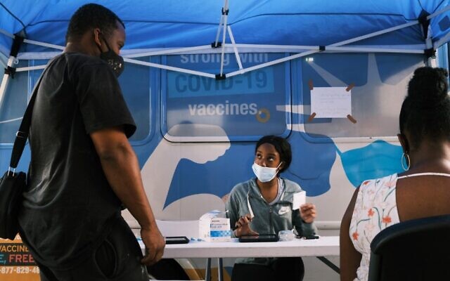 Illustrative: People sign-up for a shot at a city-operated mobile pharmacy for the COVID-19 vaccine in a Brooklyn neighborhood on July 30, 2021 in New York City. (SPENCER PLATT / Getty Images via AFP)