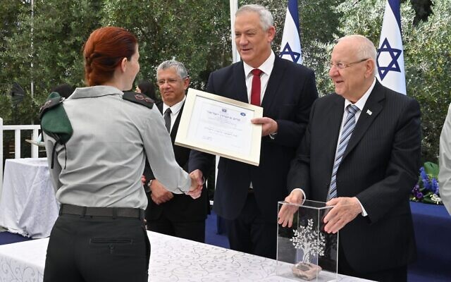 Defense Minister Benny Gantz awards Israel's Golomb Security Prize to an unnamed Military Intelligence Officer, alongside President Reuven Rivlin, right, and Defense Ministry Director-General Amir Eshel, at the President's Residence in Jerusalem on July 5, 2021. (Ariel Hermoni/Defense Ministry)