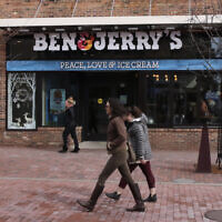 Pedestrians walk on Church Street, past the Ben & Jerry's shop, in Burlington, Vermont, March 11, 2020. (AP Photo/Charles Krupa)