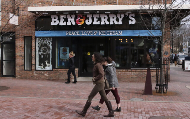 Pedestrians walk on Church St., past the Ben & Jerry's shop, in Burlington, Vermont, March 11, 2020. (AP Photo/Charles Krupa)
