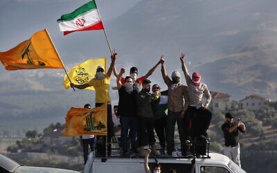 Hezbollah supporters wave their group and Iranian flags during a protest on the Lebanese-Israeli border near the southern village of Kafr Kila, Lebanon, May 14, 2021. (AP Photo/Mohammed Zaatari)