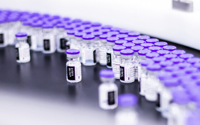 In this March 2021 photo provided by Pfizer, vials of the Pfizer-BioNTech COVID-19 vaccine are prepared for packaging at the company’s facility in Puurs, Belgium. (Pfizer via AP)
