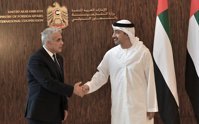 Foreign Minister Yair Lapid shakes hands with United Arab Emirates Foreign Minister Sheikh Abdullah bin Zayed al-Nahyan in Abu Dhabi, United Arab Emirates, June 29, 2021. (Shlomi Amsalem/Government Press Office via AP)