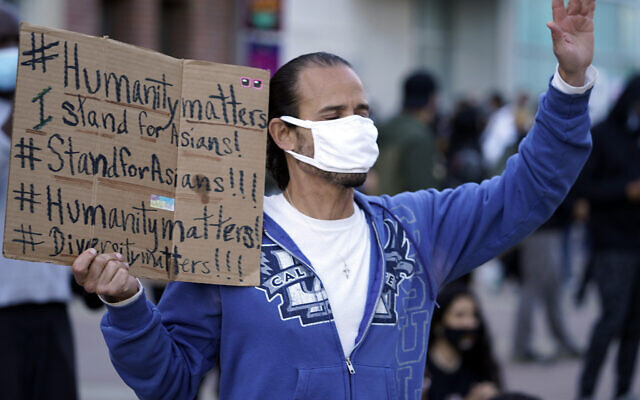 In this March 13, 2021, file photo, a man participates in the rally "Love Our Communities: Build Collective Power" to raise awareness of anti-Asian violence outside the Japanese American National Museum in Little Tokyo in Los Angeles.  (AP Photo/Damian Dovarganes, File)