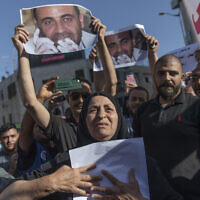 Maryam Banat, 67, mother of Palestinian Authority critic Nizar Banat, holds a poster with his picture at a rally protesting his death at the hands of PA security forces, in the West Bank city of Ramallah, on July 3, 2021. (AP Photo/Nasser Nasser)