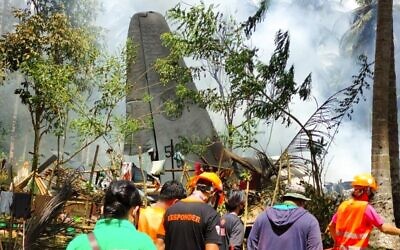In this photo released by the Joint Task Force - Sulu, rescuers search for bodies from the site where a Philippine military C-130 plane crashed in Patikul town, Jolo province, southern Philippines on July 4, 2021. (Joint Task Force-Sulu via AP)