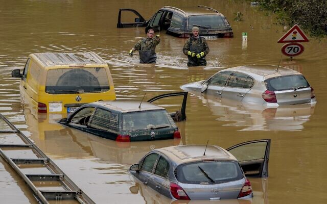 Rescuers check for victims in flooded cars on a road in Erftstadt, Germany, on July 17, 2021. (AP Photo/Michael Probst)