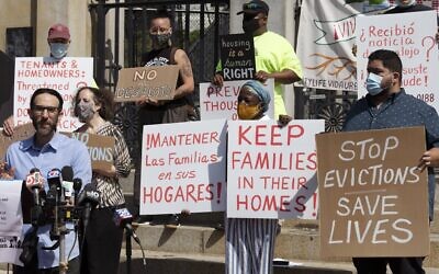 People from a coalition of housing justice groups hold signs protesting evictions during a news conference outside the Statehouse, July 30, 2021, in Boston. (AP Photo/Michael Dwyer)