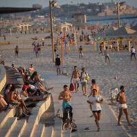 Illustrative: Israelis enjoy the beach in Tel Aviv on a hot summer day, on July 6, 2021. (Miriam Alster/Flash90)