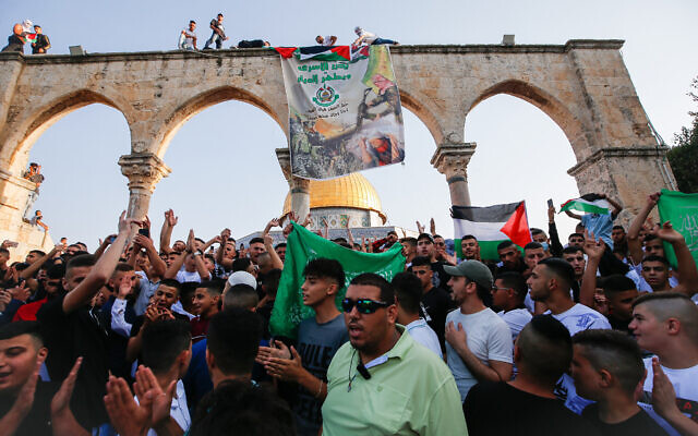 Worshippers raise the Palestinian flag and a Hamas banner following Eid al-Adha prayers on the Temple Mount, July 20, 2021. (Jamal Awad/Flash90)