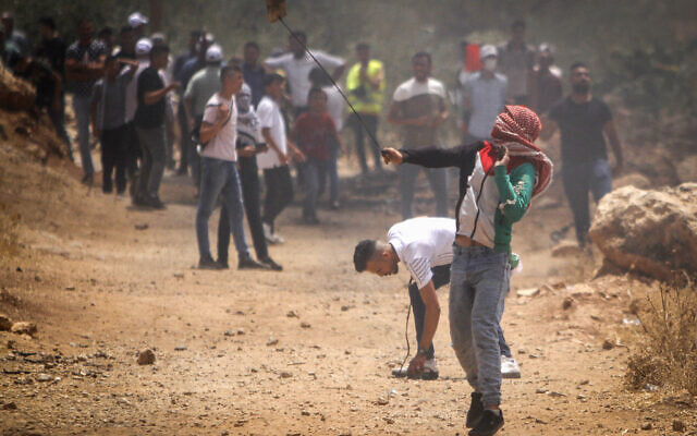 Palestinians clash with Israeli security forces during a protest in the village of Beit Dajan, near the West Bank city of Nablus on July 23, 2021.(Nasser Ishtayeh/Flash90)