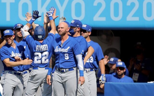 Israel's Mitchell Glasser (3rd L, #22) is congratulated by teammates on his scoring during the seventh inning of the Tokyo 2020 Olympic Games baseball round 1 game between Israel and Mexico at Yokohama Baseball Stadium in Yokohama, Japan, on August 1, 2021. (KAZUHIRO FUJIHARA / AFP)