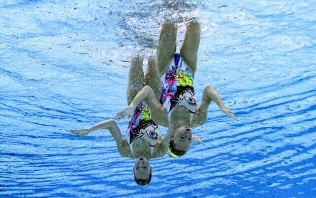 An underwater view shows Israel's Eden Blecher and Shelly Bobritsky compete in the preliminary for the women's duet free artistic swimming event during the Tokyo 2020 Olympic Games at the Tokyo Aquatics Centre in Tokyo on August 2, 2021. (François-Xavier MARIT / AFP)