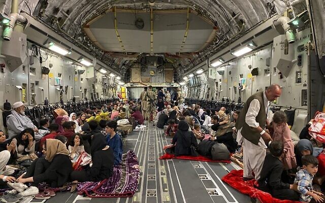 Illustrative: Afghan people sit inside a US military aircraft to leave Afghanistan, at the military airport in Kabul on August 19, 2021 after Taliban's military takeover of Afghanistan. (Shakib RAHMANI / AFP)