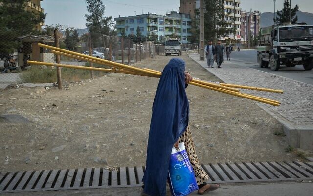 A burqa-clad Afghan woman walks along a path in Kabul on August 30, 2021. (Hoshang Hashimi / AFP)