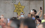 In this July 24, 2021, file photo, people stage a protest against the 'green pass' in Milan, Italy. Protesters in Italy and in France have been wearing yellow Stars of David, like the ones Nazis required Jews to wear to identify themselves during the Holocaust. Some carry signs likening vaccine passes to  dictatorships. (AP Photo/Antonio Calanni, File)