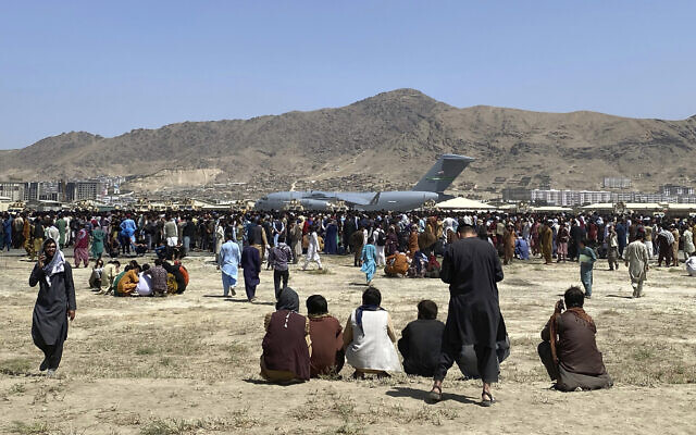 Hundreds of people gather near a US Air Force C-17 transport plane at a perimeter at the international airport in Kabul, Afghanistan, August 16, 2021. (AP Photo/Shekib Rahmani)