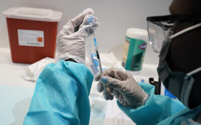 A healthcare worker fills a syringe with the Pfizer COVID-19 vaccine at the American Museum of Natural History in New York, July 22, 2021. (AP Photo/Mary Altaffer, File)