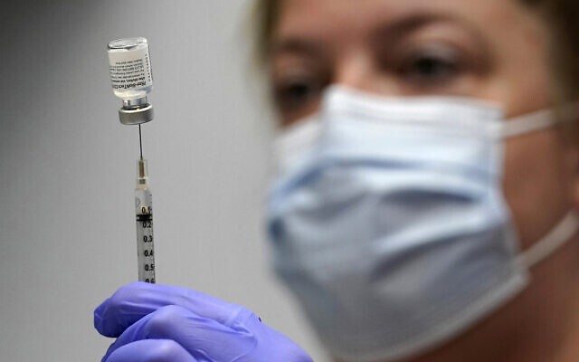 In this March 2, 2021, file photo, pharmacy technician Hollie Maloney loads a syringe with Pfizer's COVID-19 vaccine at the Portland Expo in Portland, Maine. (AP/Robert F. Bukaty, File)