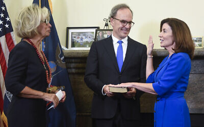 New York Chief Judge Janet DiFiore, left, swears in Kathy Hochul, right, as the first woman to be New York's governor while her husband, Bill Hochul, holds a bible during a swearing-in ceremony in the Red Room at the state Capitol, early Tuesday, Aug. 24, 2021, in Albany, N.Y. (AP Photo/Hans Pennink, Pool)