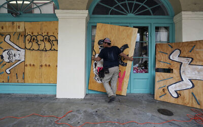 In preparation of Hurricane Ida, a US worker attaches protective plywood to windows and doors of a business in the French Quarter in New Orleans, August 28, 2021. (AP Photo/Eric Gay)