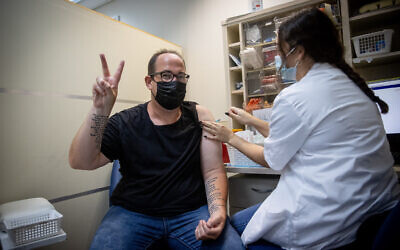 An Israeli man receives a third dose of the COVID-19 vaccine, at a Maccabi healthcare services vaccination center, on August 22, 2021. (Yonatan Sindel/Flash90)