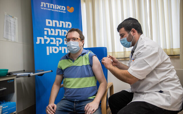 A man receives a third dose of the COVID-19 vaccine at a Meuhedet vaccination center in Jerusalem on August 24, 2021. (Yonatan Sindel/Flash90)