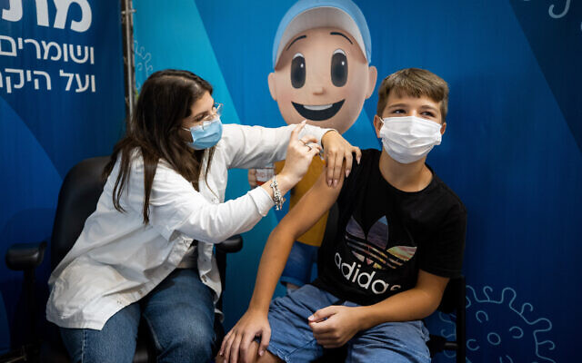 13-year-old Tomer Zarfati receives his second dose of the COVID-19 vaccine at a temporary Clalit health care center in Jerusalem, August 29, 2021. (Yonatan Sindel/Flash90)