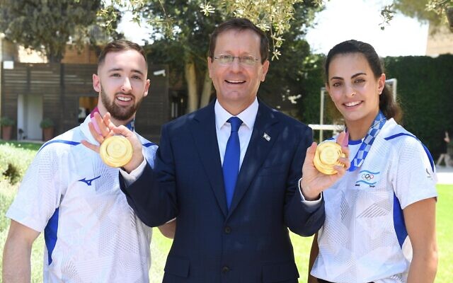 Artem Dolgopyat (L) President Isaac Herzog (C) and Linoy Ashram (R) with their Olympic gold medals at the President's Residence in Jerusalem, August 16, 2021 (Itay Beit-On/GPO)