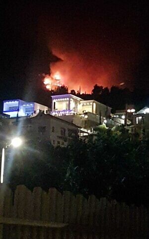 Fires are seen on the Ramim Ridge behind homes in Kiryat Shmona on August 4, 2021. (Dikla Attiyah/Kiryat Shmona municipality)