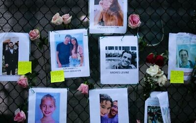 Photos of missing residents are posted at a makeshift memorial at the site of a collapsed building in Surfside, Florida, north of Miami Beach,on June 26, 2021. (Photo by Andrea SARCOS / AFP)