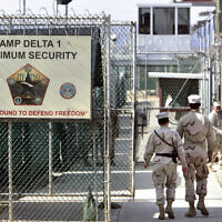 In this June 27, 2006 file photo, reviewed by a US Department of Defense official, US military guards walk within Camp Delta military-run prison, at the Guantanamo Bay US Naval Base, Cuba. (AP/Brennan Linsley, File)
