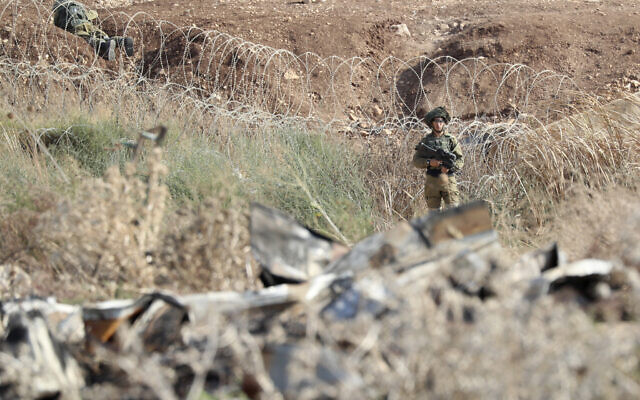 Israeli soldiers take positions along the border between the northern West Bank near Jenin and Israel as they search for two Palestinians who broke out of a maximum-security prison last week, on a road leading to the West Bank town of Jenin, near Gan Ner Israel, September 12, 2021. (AP/Ariel Schalit)