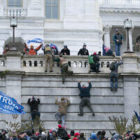 In this January 6, 2021, photo, violent insurrectionists loyal to President Donald Trump scale the west wall of the the US Capitol in Washington, DC. (AP Photo/Jose Luis Magana, File)