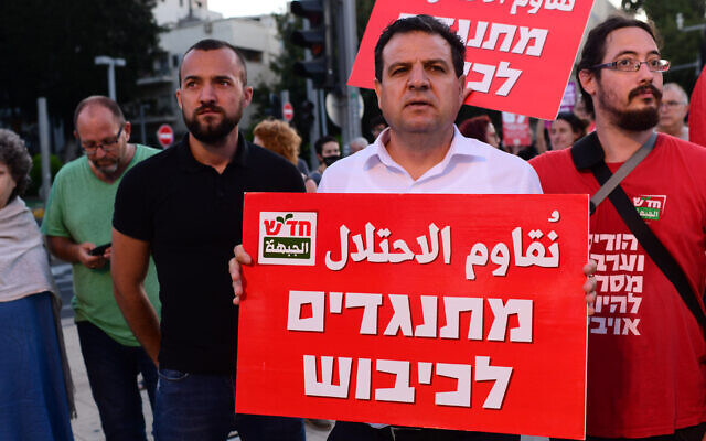 Leader of the Joint List Ayman Odeh is seen carrying a sign which reads 'Against the Occupation' during a protest in Tel Aviv, on May 15, 2021. (Tomer Neuberg/Flash90)