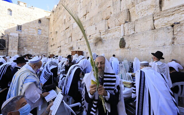 Worshippers pray in front of the Western Wall in Jerusalem's Old City, during the priestly blessing for the festival of Sukkot, on September 22, 2021. (Olivier Fitoussi/Flash90)