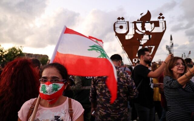 Protesters gather in front of the 'October 17 torch' near the devastated port of Beirut, during a rally to mark the second anniversary of the beginning of a nationwide anti-government protest movement, on October 17, 2021. (Anwar Amro/AFP)