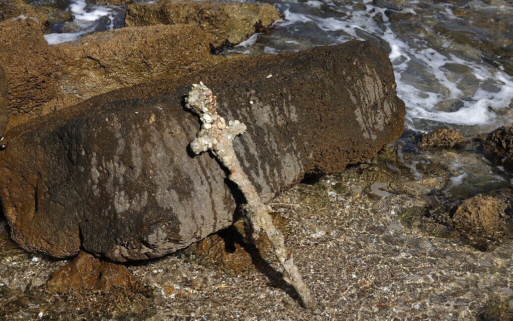 A picture taken on October 19, 2021, shows an ancient one-meter-long sword that experts say dates back to the Crusader-era and is believed to have belonged to a Crusader, displayed at the beach in Caesarea, days after being discovered by a local diver. (Jack GUEZ / AFP)