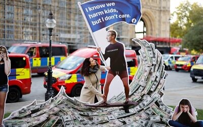A demonstrator poses with an installation depicting Facebook founder Mark Zuckerberg surfing on a wave of cash and surrounded by distressed teenagers, during a protest opposite the Houses of Parliament in central London as Facebook whistleblower Frances Haugen was set to testify to British lawmakers, on October 25, 2021. (Tolga Akmen / AFP)