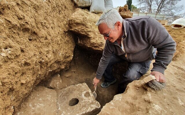 Israel Antiquities Authority archaeologist Yaakov Billig next to the toilet discovery. (Yoli Schwartz/IAA)