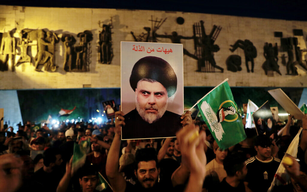 Followers of Shiite cleric Muqtada al-Sadr celebrate holding his posters, after the announcement of the results of the parliamentary elections in Tahrir Square, Baghdad, Iraq, on October 11, 2021. (AP Photo/Khalid Mohammed)