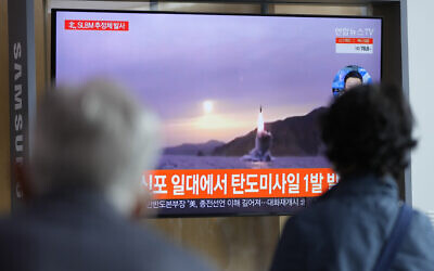 People watch a TV screen showing a news program reporting about North Korea's missile launch with file footage at a train station in Seoul, South Korea, October 19, 2021. (Lee Jin-man/AP)