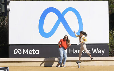 Facebook employees take a photo with the company's new name and logo outside its headquarters in Menlo Park, Calif., on Thursday, October 28, 2021, after the company announced that it is changing its name to Meta Platforms Inc. (AP Photo/Tony Avelar)
