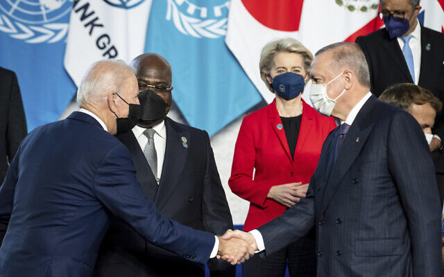 US President Joe Biden, left, shakes hands with Turkish President Recep Tayyip Erdogan ahead of the opening session of the G20 summit at the La Nuvola conference center, in Rome, on October 30, 2021. (Erin Schaff/Pool Photo via AP)