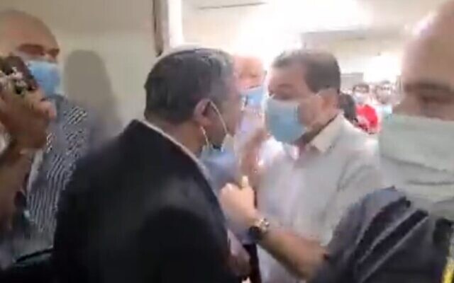 Screen capture from video of an altercation between leader of the far-right Otzma Yehudit party MK Itamar Ben Gvir (center left) and MK Ayman Odeh, leader of the predominantly Arab-Israeli Joint List party, at the Kaplan Medical Center in Rehovot, October 19, 2021. (Twitter)