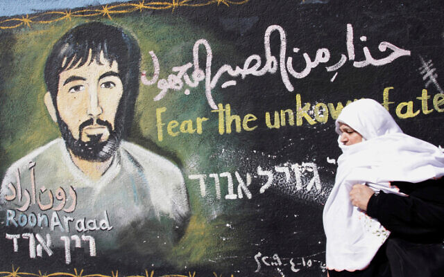 A Palestinian woman walks past a mural painted by a Hamas artist of captured Israeli soldier Ron Arad, in the Jabalia refugee camp on the Gaza Strip. on January 28, 2010. (Abed Rahim Khatib/Flash90)