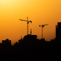 A construction site in Jerusalem against the backdrop of a sunset, September 1, 2021. (Nati Shohat/Flash90)